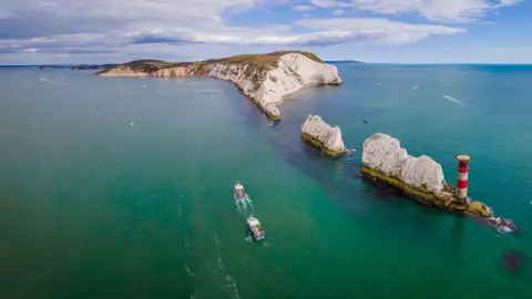 Getty Images A drone image of the white cliffs and the needles rocks on the Isle of Wight coast with boats in the water.