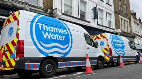 Image of Thames Water vans parked on a road as repair and maintenance work takes place in April