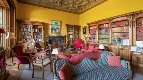 Knight Frank A large library-type room with book cases and numerous comfortable chairs