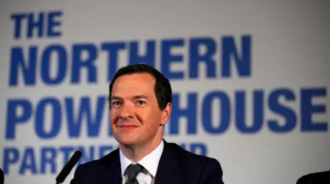 Reuters Image is George Osbourne in a black suit and tie with a white shirt, with a microhphone infront of him.
Behind him is a large sign with blue letters saying 'Northern Powerhouse Partnership'. 