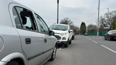 A silver car with smashed windows