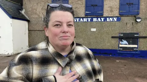 Lizzy Mooney in front of the Start Bay Inn at Torcross.