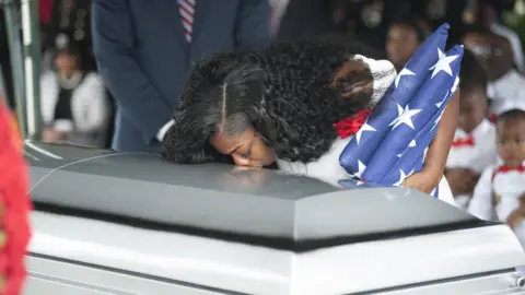 AFP Myeshia Johnson kisses the casket of her husband Army Sgt La David Johnson during his burial service in Florida, after Sgt Johnson and three other US soldiers were killed in an ambush in Niger on 4 October 2017