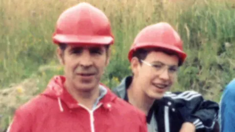 Adam Price Young Adam with his dad Rufus Price, wearing red hard hats