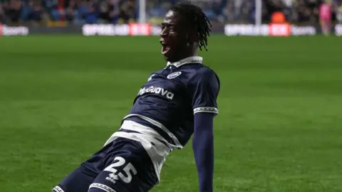 Romain Esse slides on his knees after scoring for Millwall