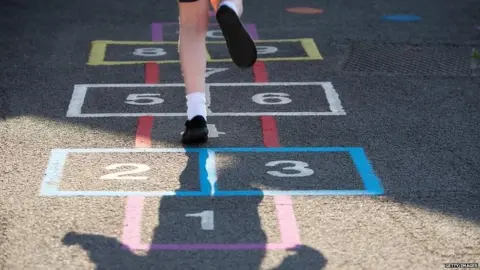 Getty Images School girl playing hopscotch