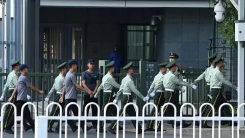 Getty Images Chinese paramilitaire politieagenten marcheren op 19 september 2024 langs de ingang van de Japanse ambassade in Peking.