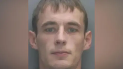 Merseyside Police A police mugshot of Dylan Westall, who has brown hair and stares into the camera with a serious expression.
