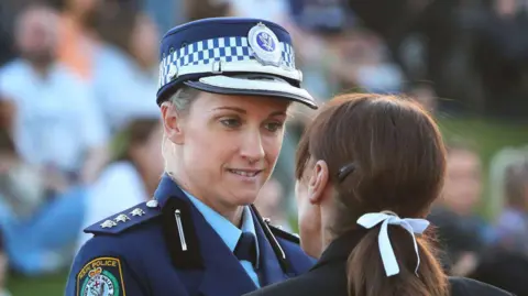 Police officer Amy Scott speaks to a woman 