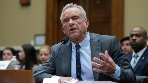 Health Secretary Robert F Kennedy Jr wearing a grey suit addressing a congressional hearing