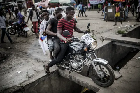 Getty Images Supporters of DR Congo opposition leader Martin Fayulu ride a motorcyle on a street in the capital Kinshasa.