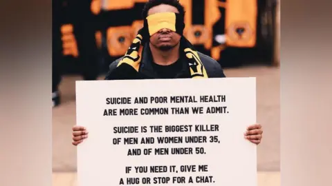 Wolves Artist Reepa holding a sign 