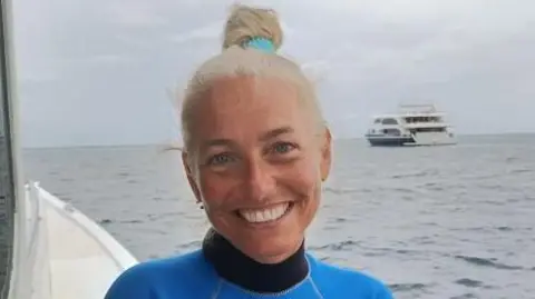 A woman smiles on a boat at sea