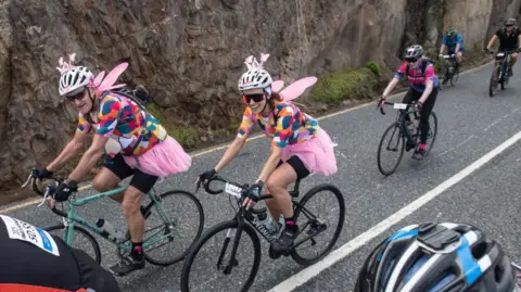 Brenton Geach / Getty Images Two cyclicts wearing fairy wings compete in the annual Cape Town Cycle Tour - Sunday 9 March 2025