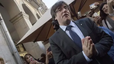 EPA Sacked Catalan leader Carles Puigdemont greets supporters at the entrance of a restaurant in Girona, 28 October 2017
