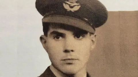 Family photo An old sepia colour photo of a young Stanley Booker in his RAF uniform. His peaked cap is at a slight angle and bears the RAF emblem.