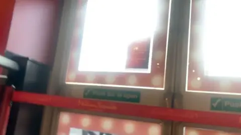 Handout A set of doors with "push bar to open" written on them with a red fabric barrier in front of them