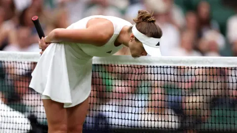 PA Elina Svitolina kisses the net during the ladies quarter final match against Iga Swiatek on day nine of the 2023 Wimbledon Championships at the All England Lawn Tennis and Croquet Club in Wimbledon.
