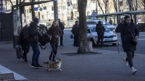 Anadolu Agency / Getty Images People leave the Zhuliany neighbourhood in Kyiv t on February 26, 2022