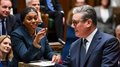 A split screen of Kemi Badenoch and Keir Starmer debating in the Commons