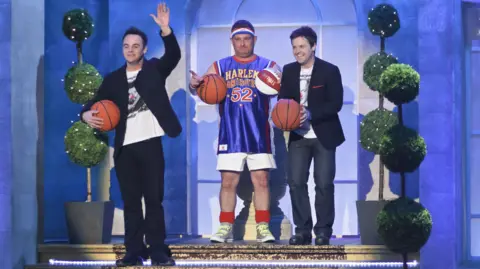 Steve Meddle/Shutterstock A younger Andy Collins and Ant and Dec in a TV studio