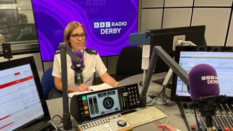 Supt Rebecca Webster, wearing police uniform, sitting in BBC Radio Derby's studio