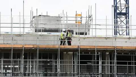 Getty Images Workers are seen on a construction site in London, where a tower block is underway.