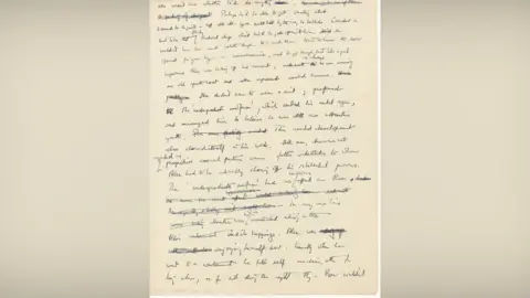 PA Media A piece of brown paper has a short novel written on it in black ink. Some of the words have been crossed out.