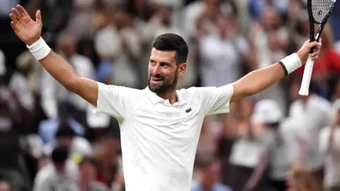 Novak Djokovic raises his arm in celebration