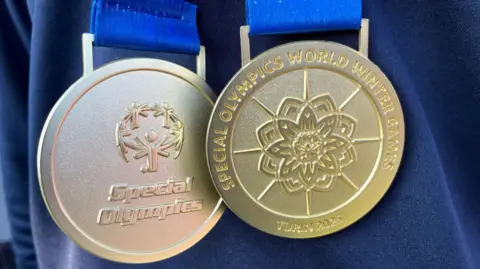 Two gold medals engraved with Special Olympics and Turin 2025. 