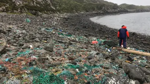 Kik-Plastic man walking across shoreline