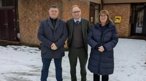 Supplied Three people stood in the snow