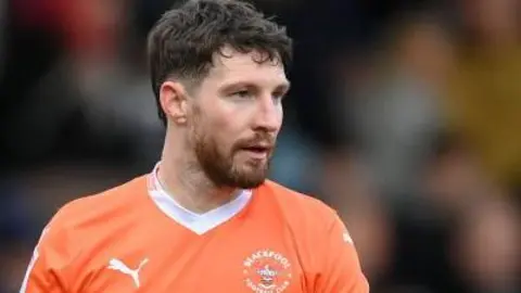Blackpool defender James Husband wearing the armband for the Tangerines