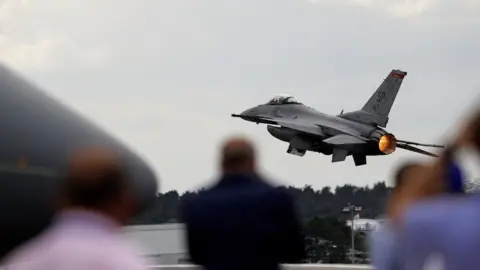 Getty Images A USAF F-16 Fighting Falcon fighter jet takes part in a flying display at the Farnborough Airshow
