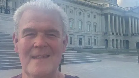 Peter Ernest A selfie of Peter Ernest in Washington DC He has short, grey hair and is smiling at the camera.