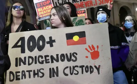 Getty Images A protester at Sydney's Black Lives Matter march holds up a sign which reads '400 indigenous deaths in custody'