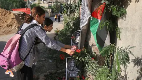 AFP Palestinian schoolgirls lay flowers at the site in Jenin where Shireen Abu Aqla was shot (12 May 2022)