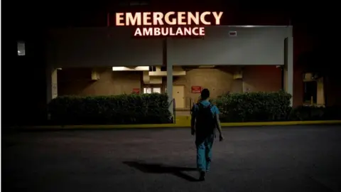 Reuters a resident ER doctor at Holy Cross Hospital, arrives at work for the start of his shift