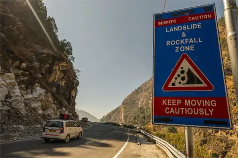 Getty Images A caution sign for a landslide and rockfall zone posted along a road in Joshimath in Chamoli district, Uttarakhand, India, on Wednesday, Feb. 9, 2022.