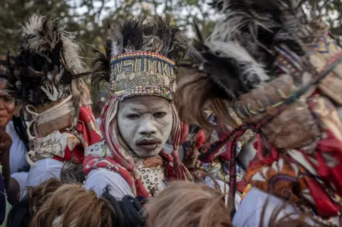 AFP Traditional dancers perform as the remains of slain Congolese independence leader Patrice Lumumba arrive on June 26, 2022 in Shilatembo where the leader was killed along with two of his compatriots