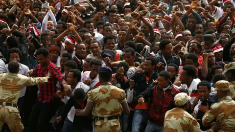 Reuters Demonstrators chant slogans while flashing the Oromo protest gesture during Irreecha in Ethiopia - 5 October 2016