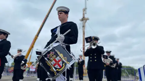 Band perform in front of mast