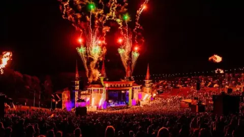 Scott Salt Wide shot of main Boomtown stage at night with a big crowd and fireworks coming from the stage