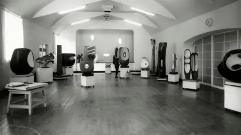 Bowness A black and white photograph showing Barbara Hepworth on the dance floor of the Palais de Danse in March 1961 with sculptures throughout the room