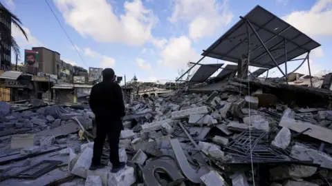 Reuters A man inspects the damage in the aftermath of Israeli strikes in Nabatieh, Lebanon, June 15,