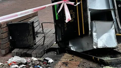 A damaged bin and bench