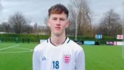 Family handout Footballer Sam Harding in his schoolboy white England kit with an 18 on the front of the shirt and the Three Lions badge