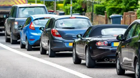 A stock shot of a queue of cars on an unidentified road.