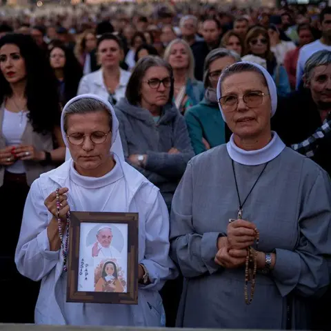 NurPhoto via Getty Images A nun holds a picture of Pope Francis as the faithful gather for Rosary prayers in honour of Pope Francis at St. Peter's Square