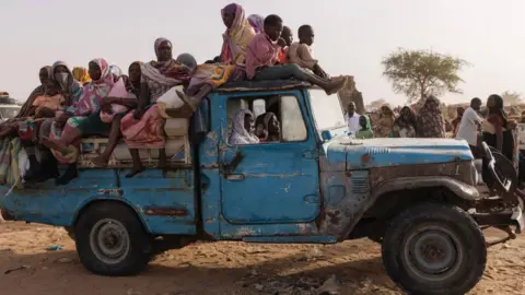 Getty Images Dozens of refugees in the Darfur region sit in the back of the truck 